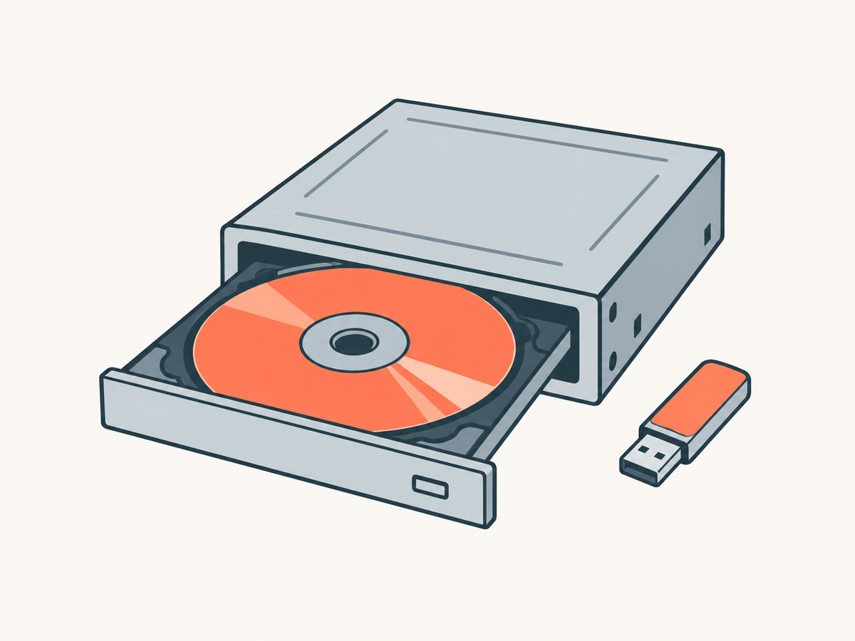 Ein DVD-Laufwerk mit herausgefahrener Schublade und einer Scheibe darin; daneben ein kleiner USB-Stick.